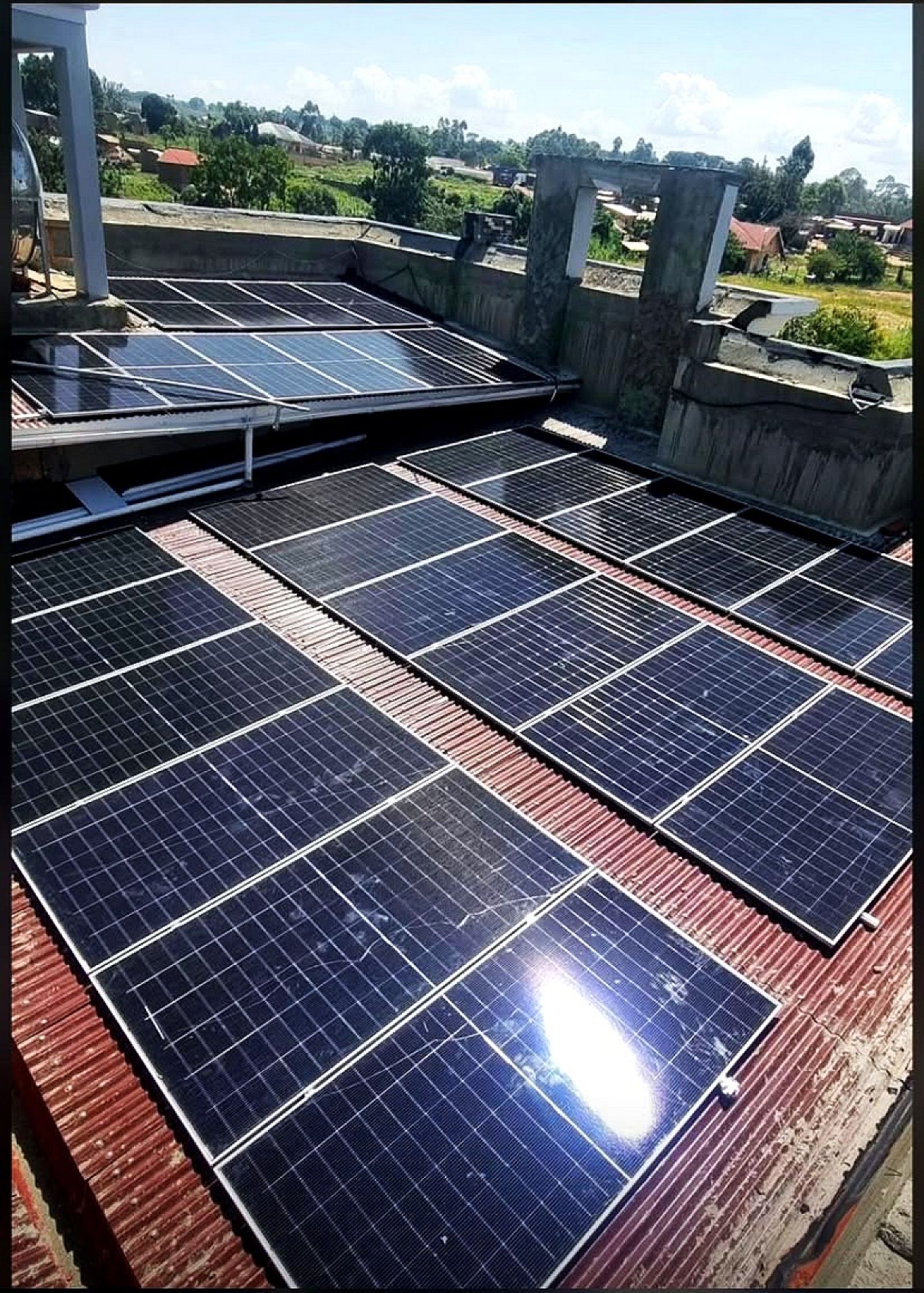 Rows of solar panels across an iron sheet roof