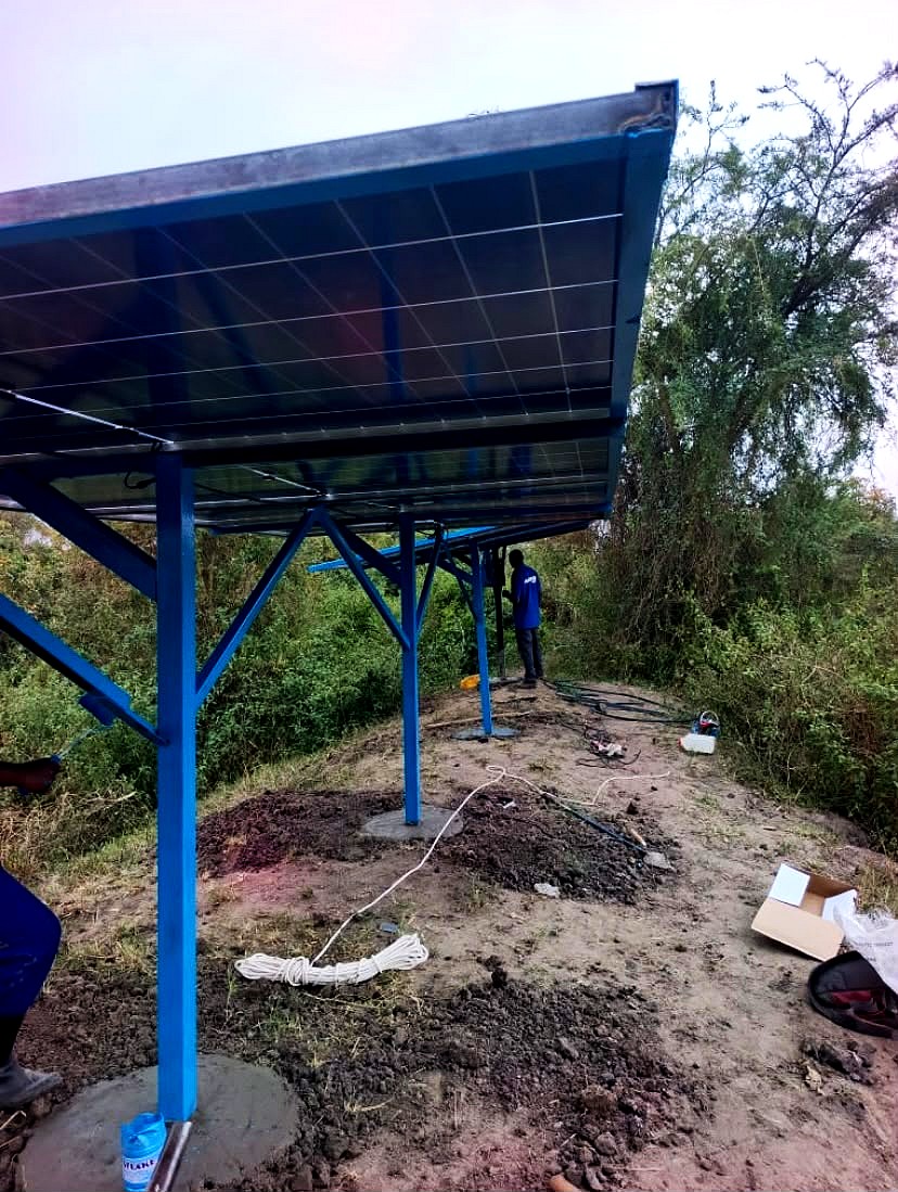 An Odowa technician working under a raised blue solar frame