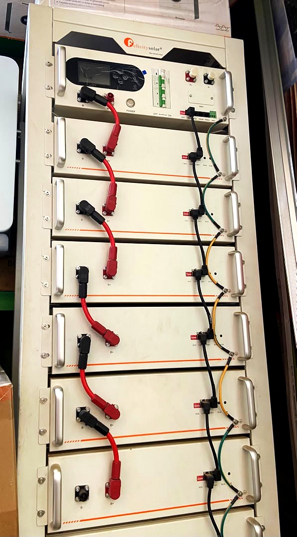 A Felicity Solar battery rack with red and black cables linking each module